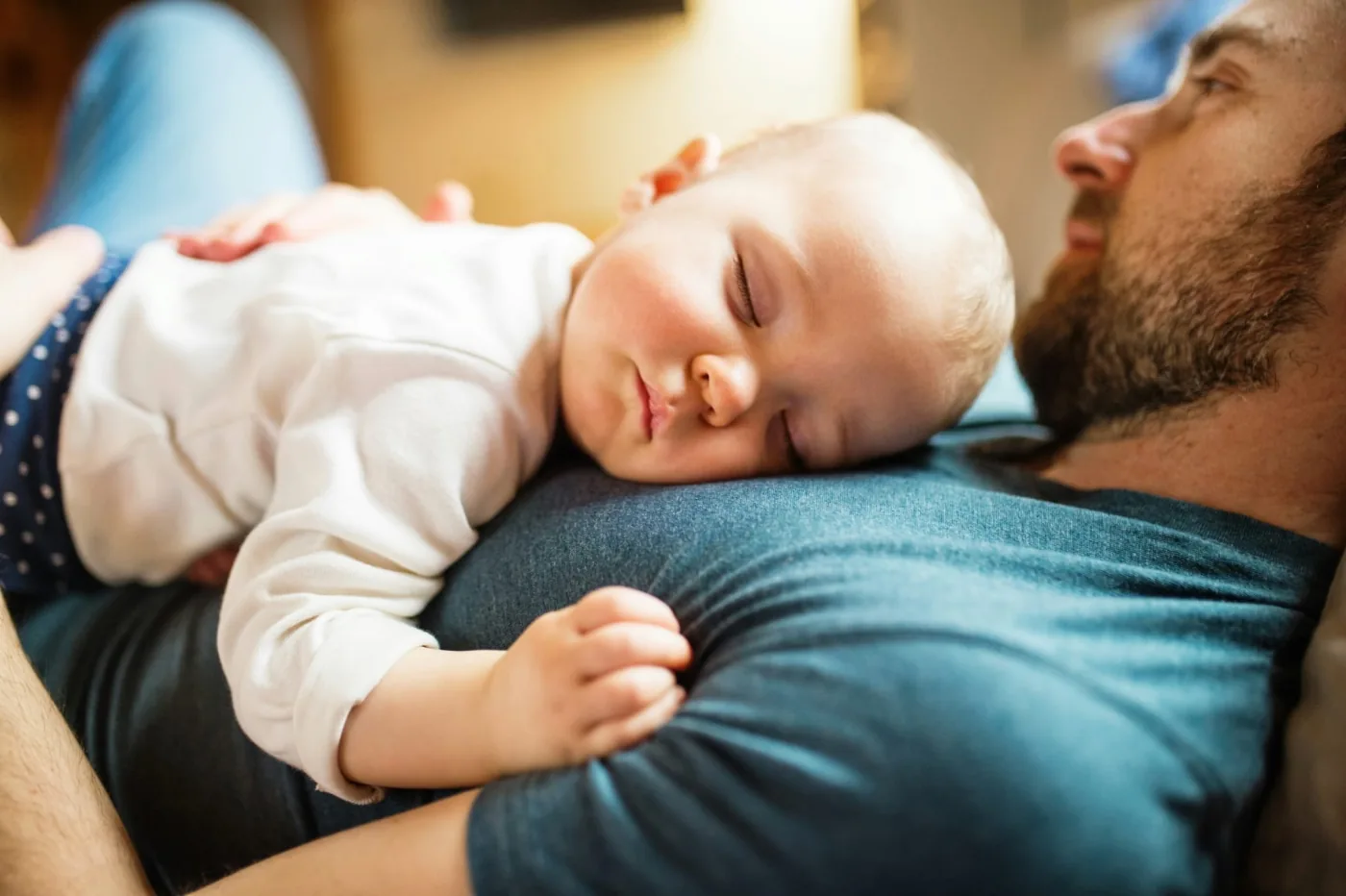 Bebé dormido sobre el regazo de su padre