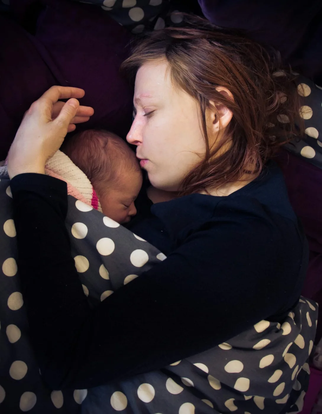Madre dormida con su bebé recién nacido contra su pecho